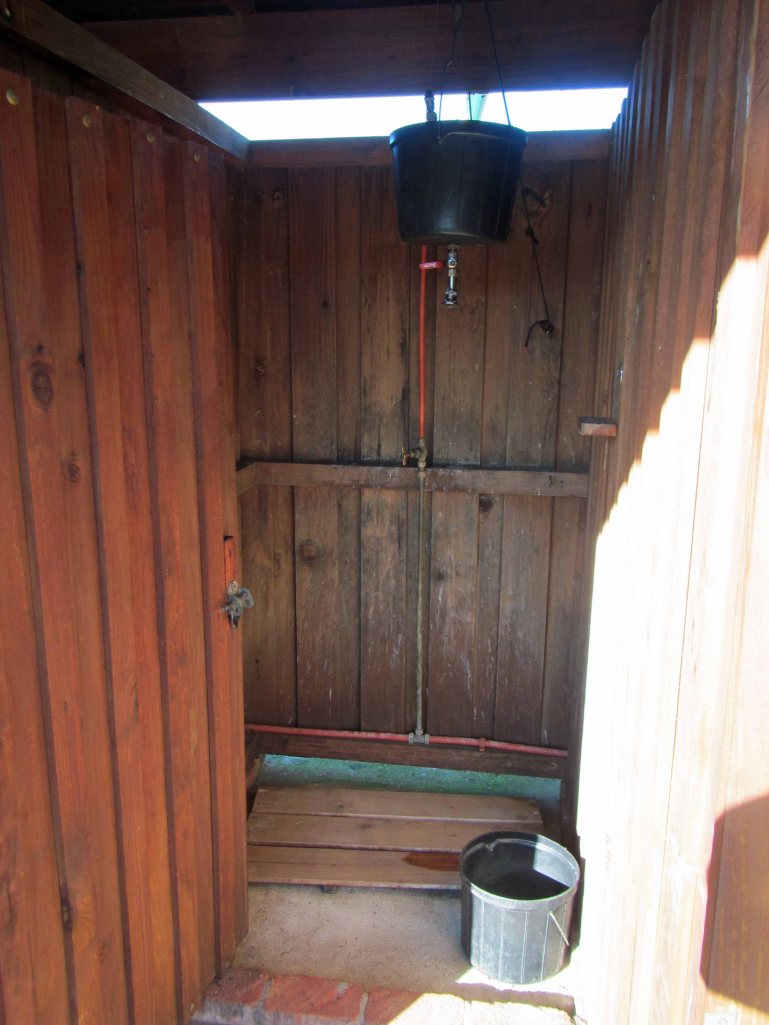 The hot water shower. You heat water in a kettle and put it in the big black bucket. After diluting the boiling water with some cool water, you can take a wonderfully refreshing hot shower that lasts a few minutes. 