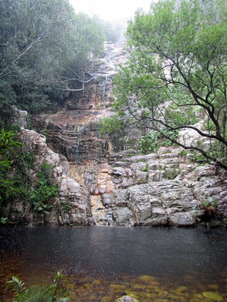 A coca-cola colored waterfall and pool. 