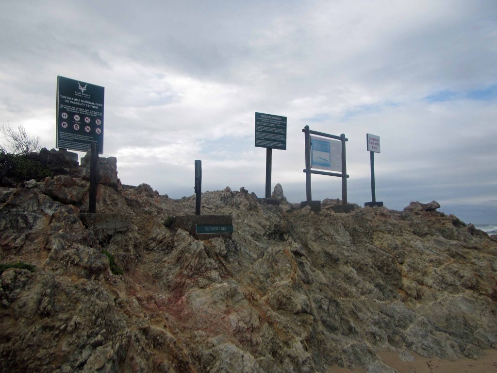 Signs on the beach, perched far above high tide and rouge waves.