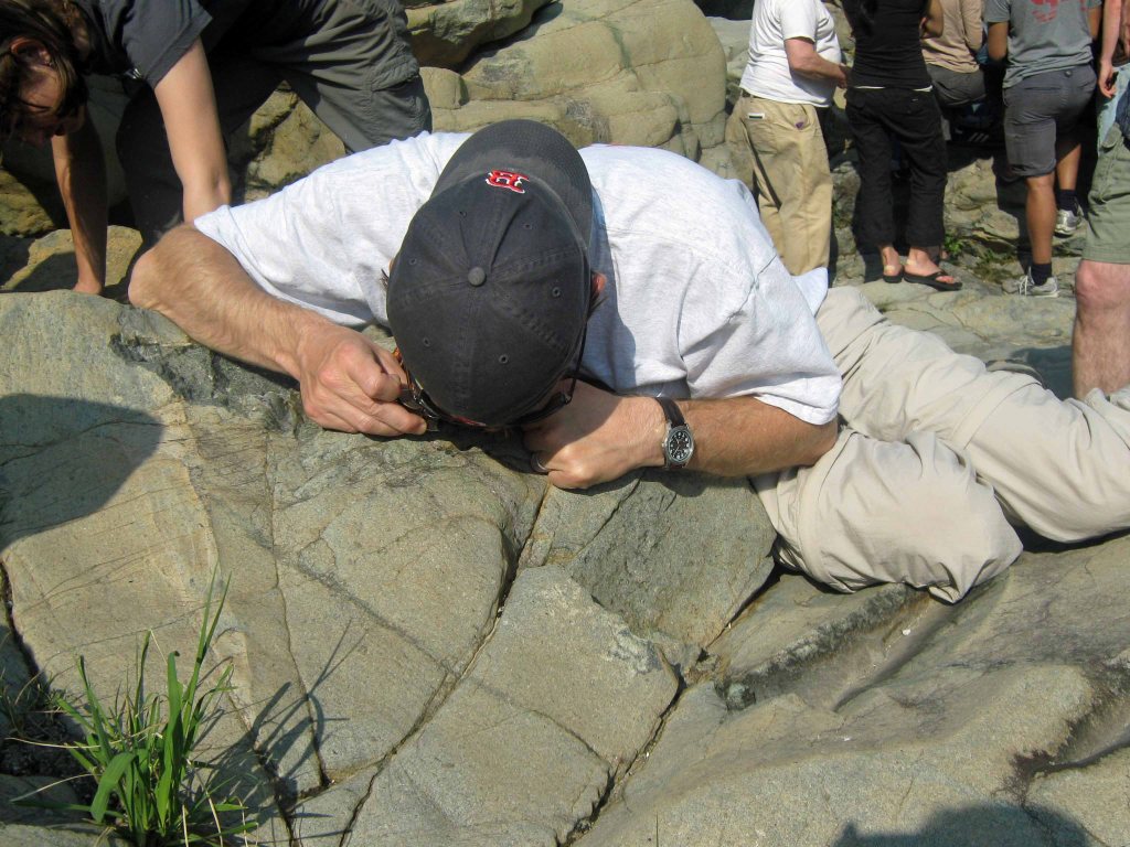 A geologist taking a good look through a hand lens. 